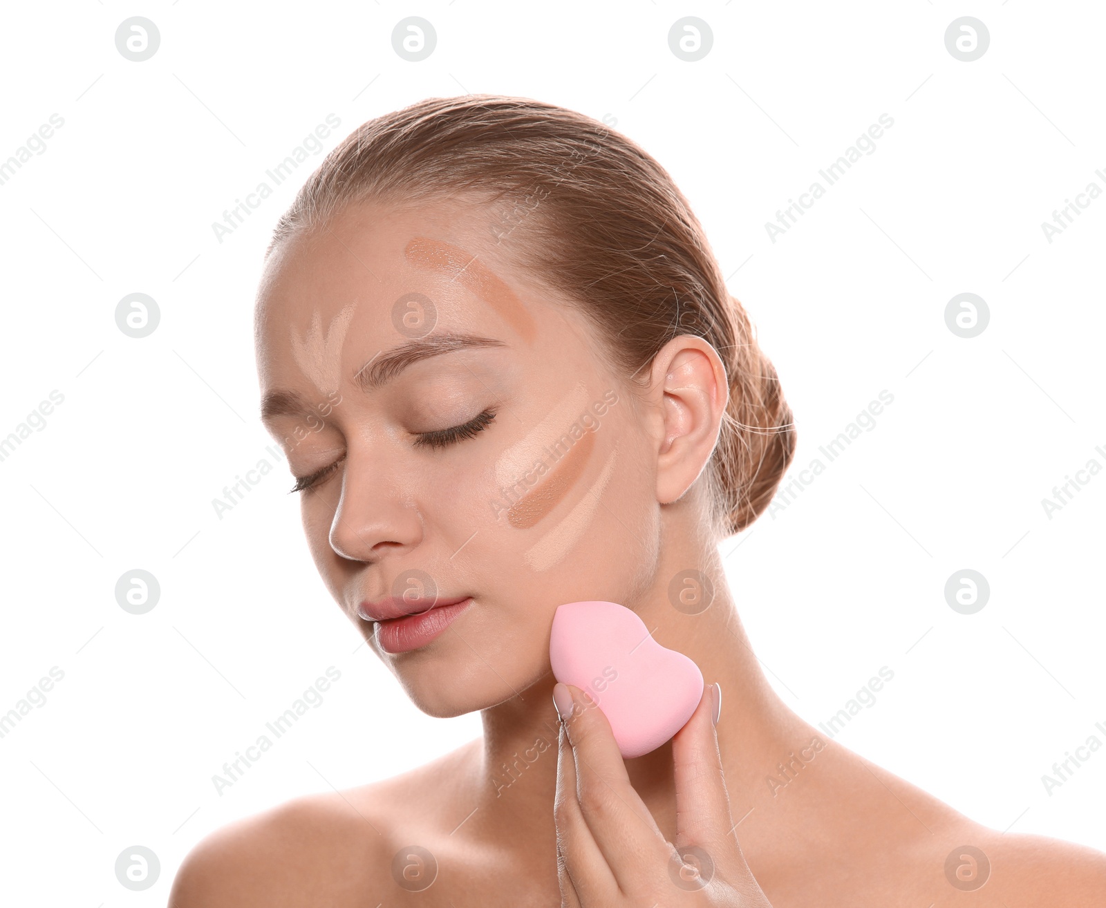 Photo of Young woman applying foundation on her face against white background