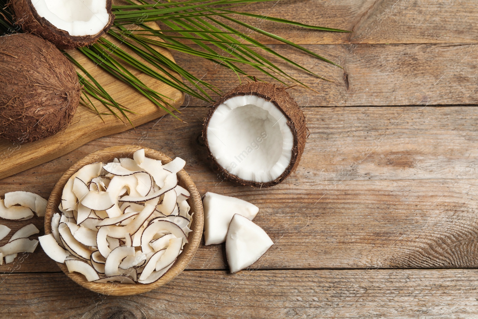 Photo of Flat lay composition with tasty coconut chips on wooden table