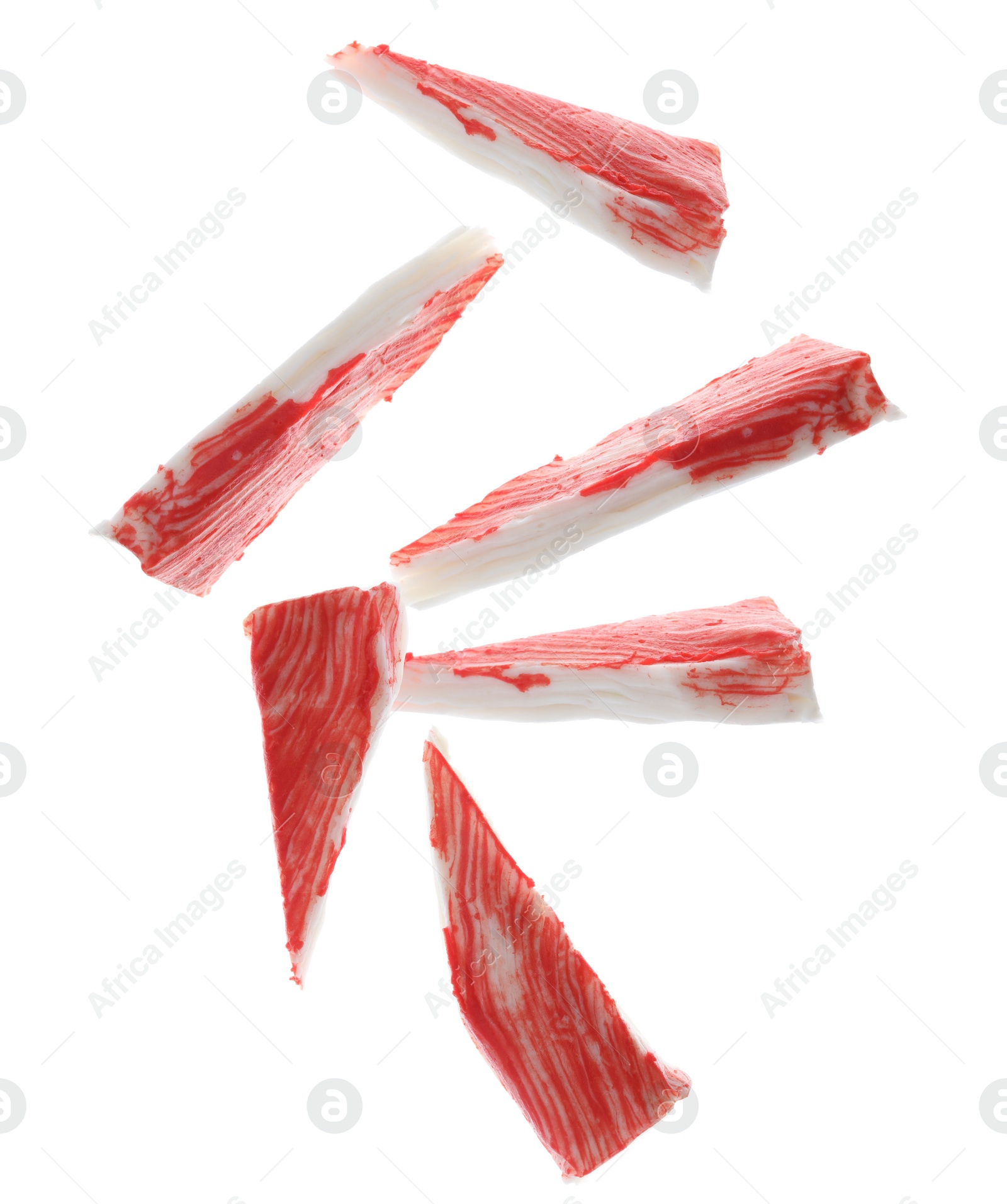 Image of Cut fresh crab sticks falling on white background