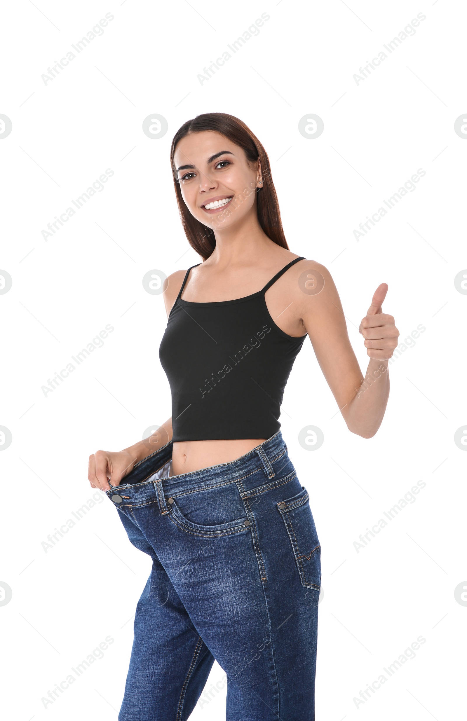 Photo of Slim woman in oversized jeans on white background. Weight loss