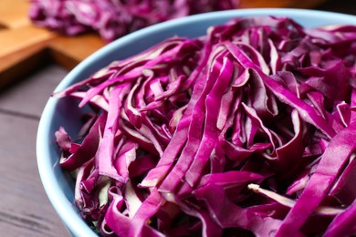 Photo of Fresh chopped red cabbage in bowl on table, closeup