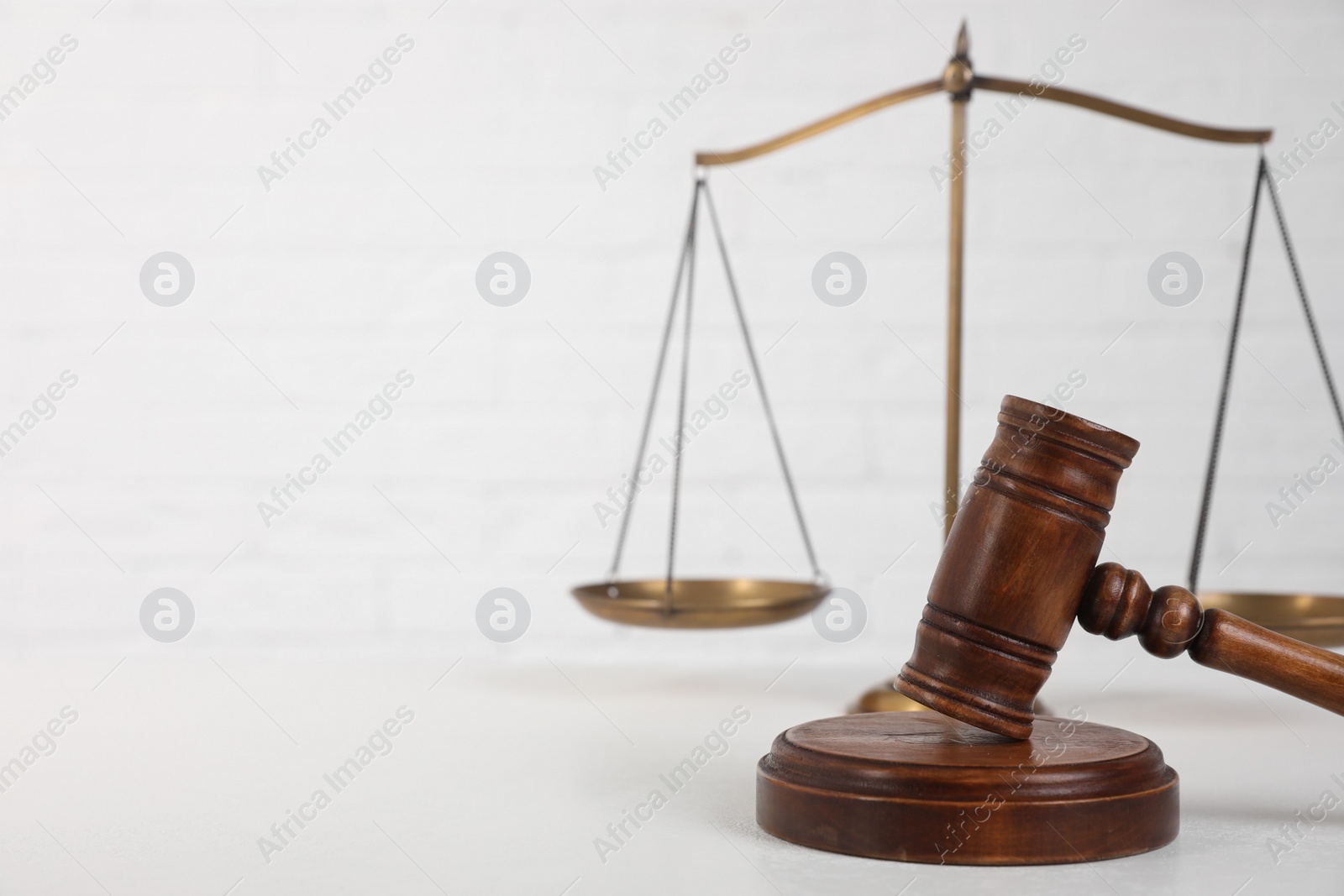 Photo of Composition with gavel and scales of justice on table against white background, space for text. Criminal law