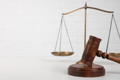 Composition with gavel and scales of justice on table against white background, space for text. Criminal law