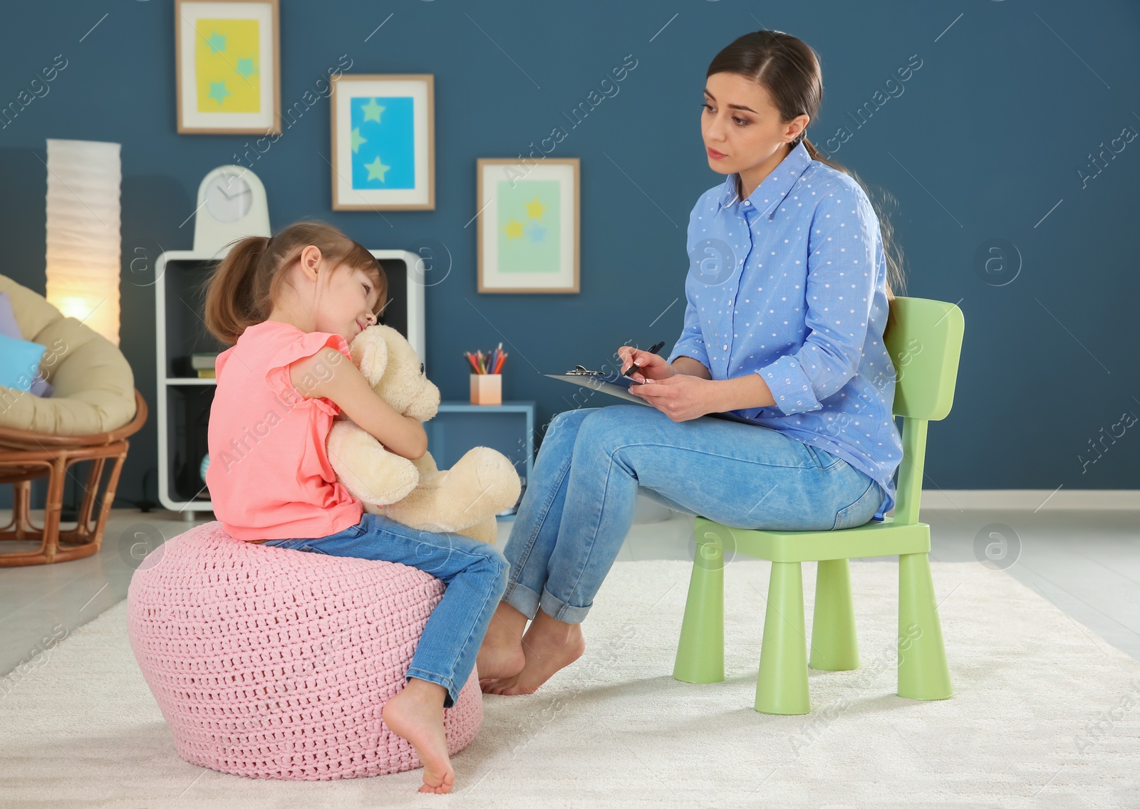 Photo of Female psychologist working with cute little girl in office