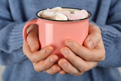 Woman holding cup of delicious hot chocolate with marshmallows, closeup