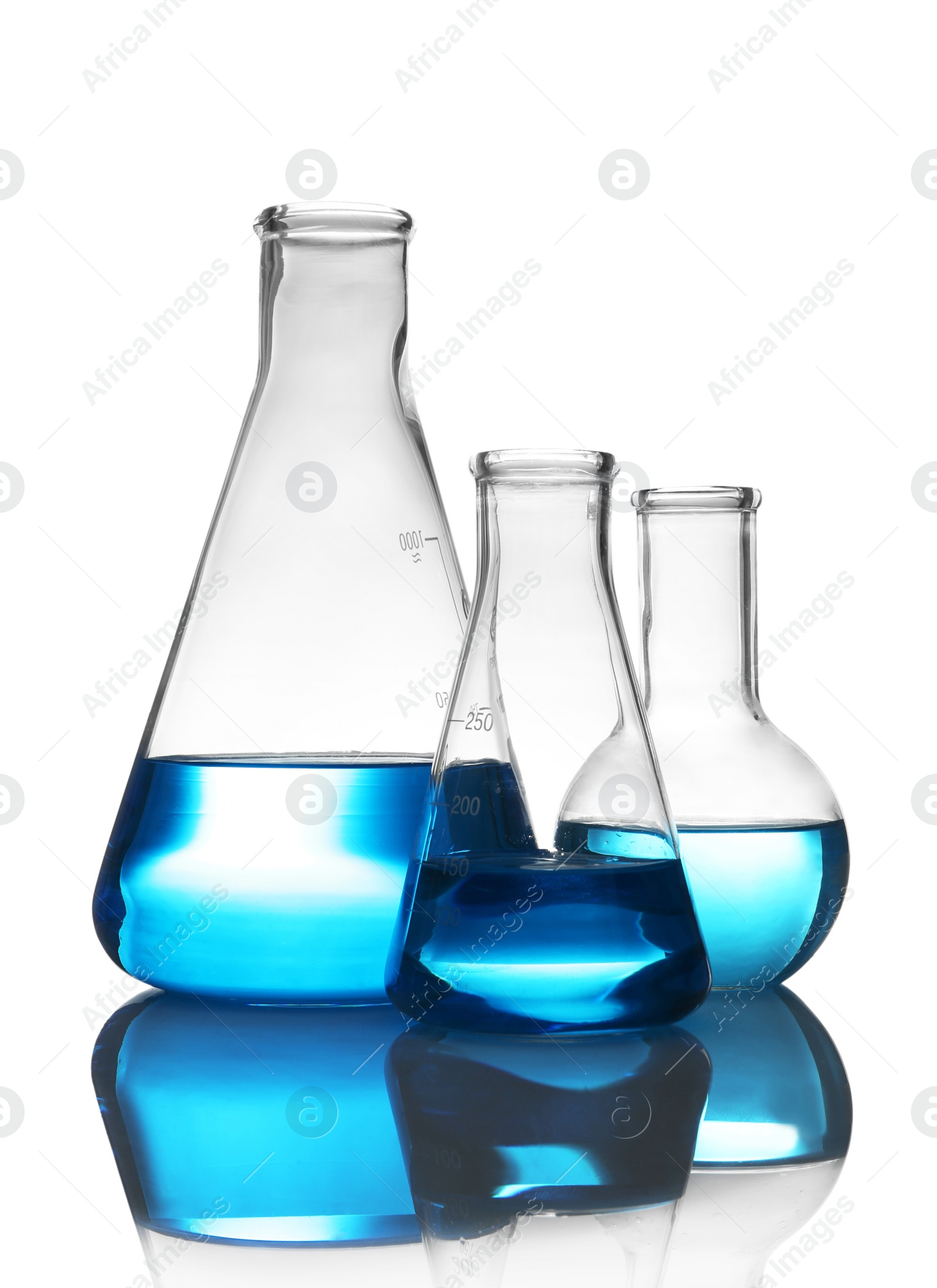 Photo of Laboratory glassware with liquid on table against white background. Chemical analysis