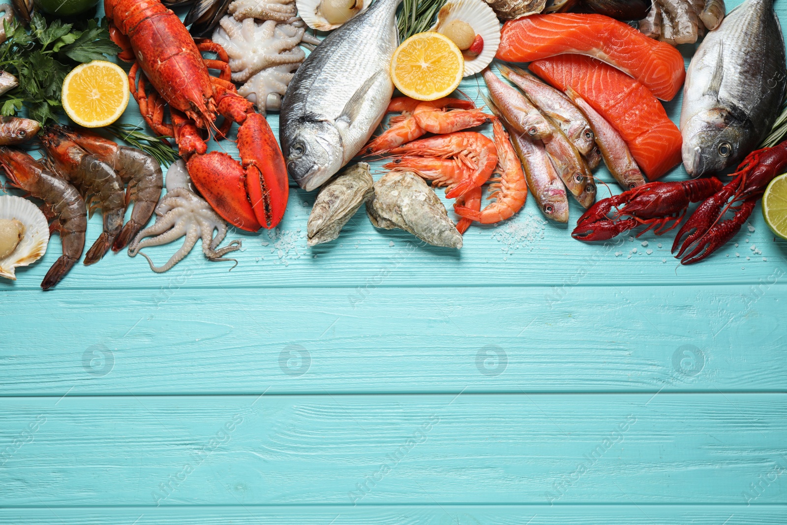 Photo of Fresh fish and different seafood on blue wooden table, flat lay. Space for text