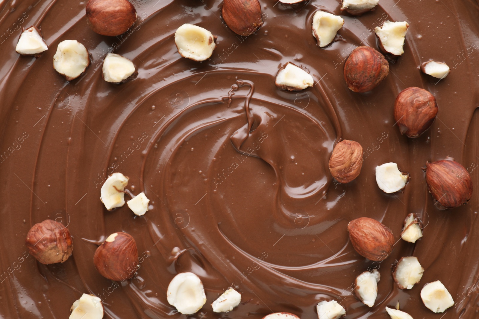 Photo of Delicious chocolate paste with nuts as background, top view