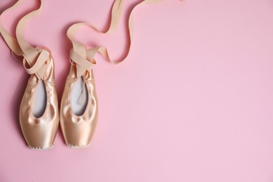 Ballet shoes. Elegant pointes on pink background, flat lay. Space for text