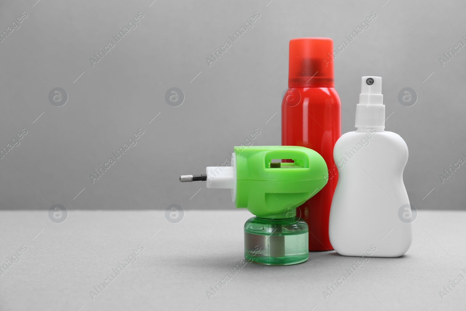 Photo of Set of different insect repellents on grey background. Space for text