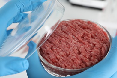 Photo of Scientist holding Petri dish with raw minced cultured meat, closeup