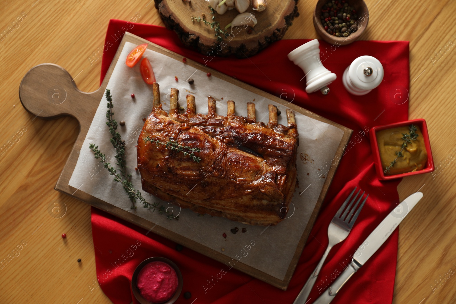 Photo of Delicious roasted ribs served on wooden table, flat lay