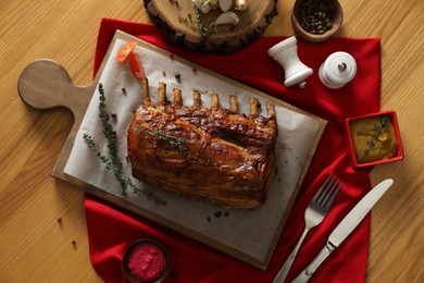 Photo of Delicious roasted ribs served on wooden table, flat lay