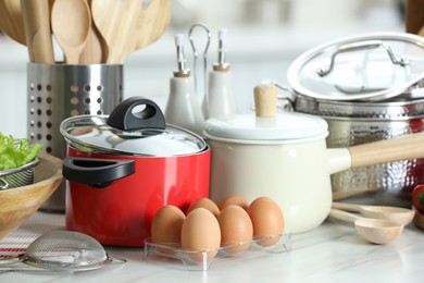 Photo of Set of cooking utensils and products on white table against blurred background