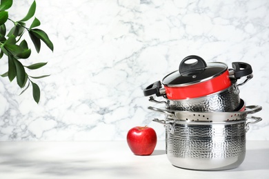 Photo of Set of clean cookware on table against light background. Space for text