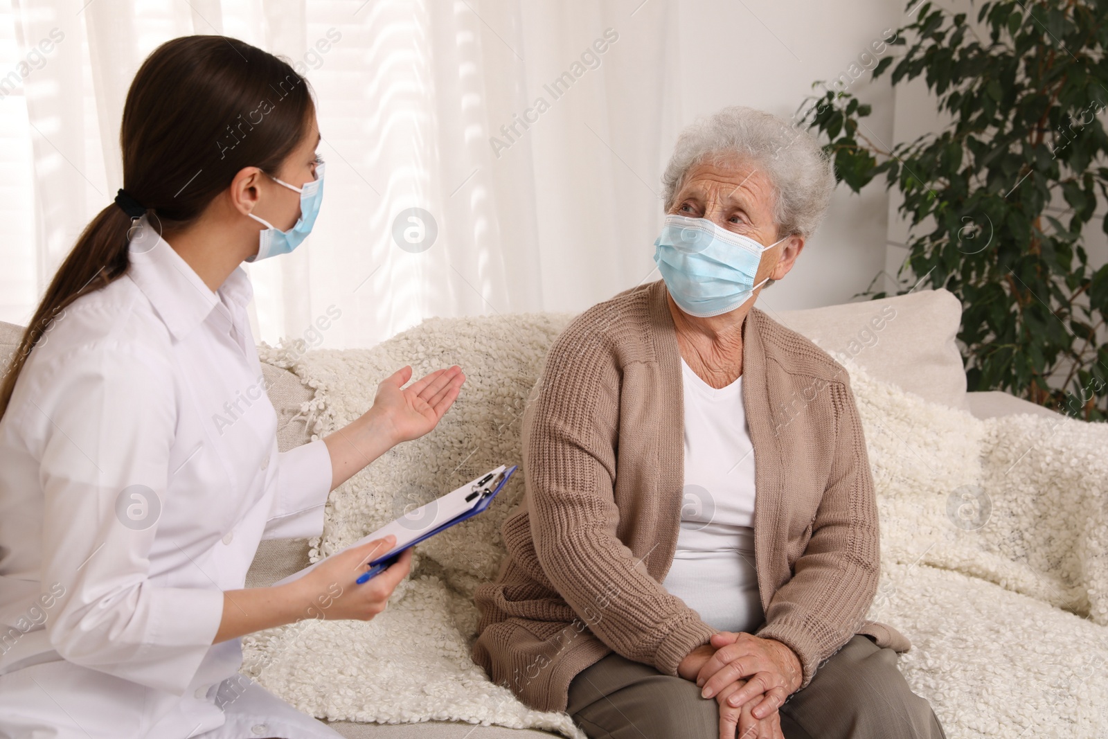 Photo of Doctor examining senior woman with protective mask at nursing home