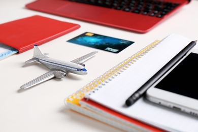 Photo of Composition with plane model, passport and credit card on white table. Travel agency