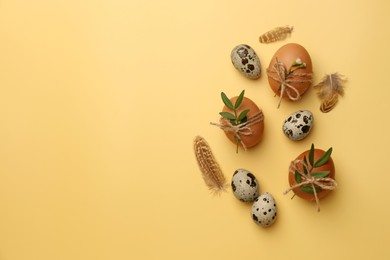 Happy Easter. Chicken and quail eggs with natural decor on yellow background, flat lay. Space for text
