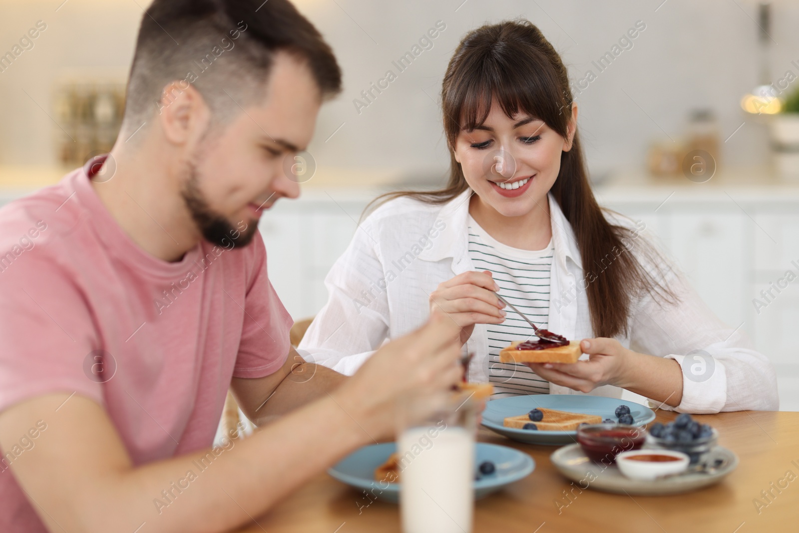 Photo of Happy couple having tasty breakfast at home, selective focus
