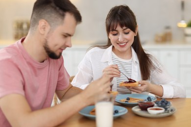 Happy couple having tasty breakfast at home, selective focus