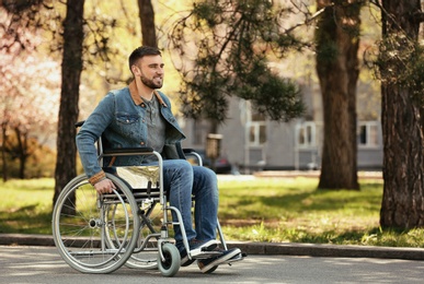 Photo of Young man in wheelchair at park on spring day