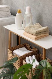 Photo of Soft towels and detergents on bench indoors