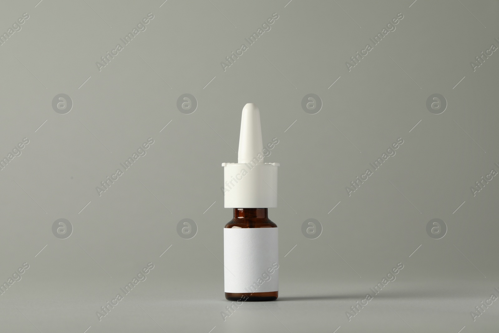 Photo of Bottle of nasal spray on light grey background