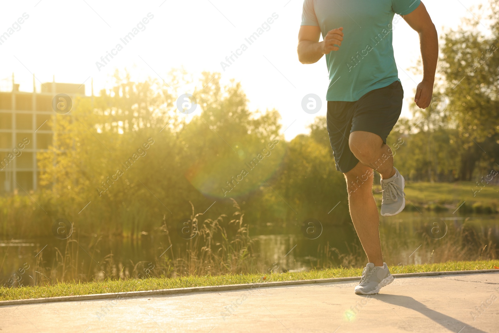 Photo of Man running near pond in park, closeup. Space for text