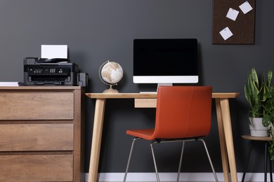 Photo of Stylish workplace with modern computer and printer at home