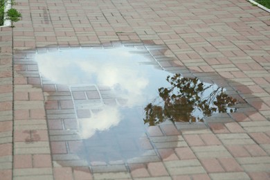 Puddle after rain on street tiles outdoors