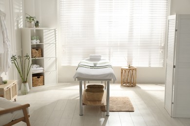 Stylish spa salon interior with massage table