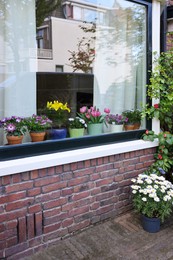 Photo of House decorated with many beautiful potted flowers, view from outside