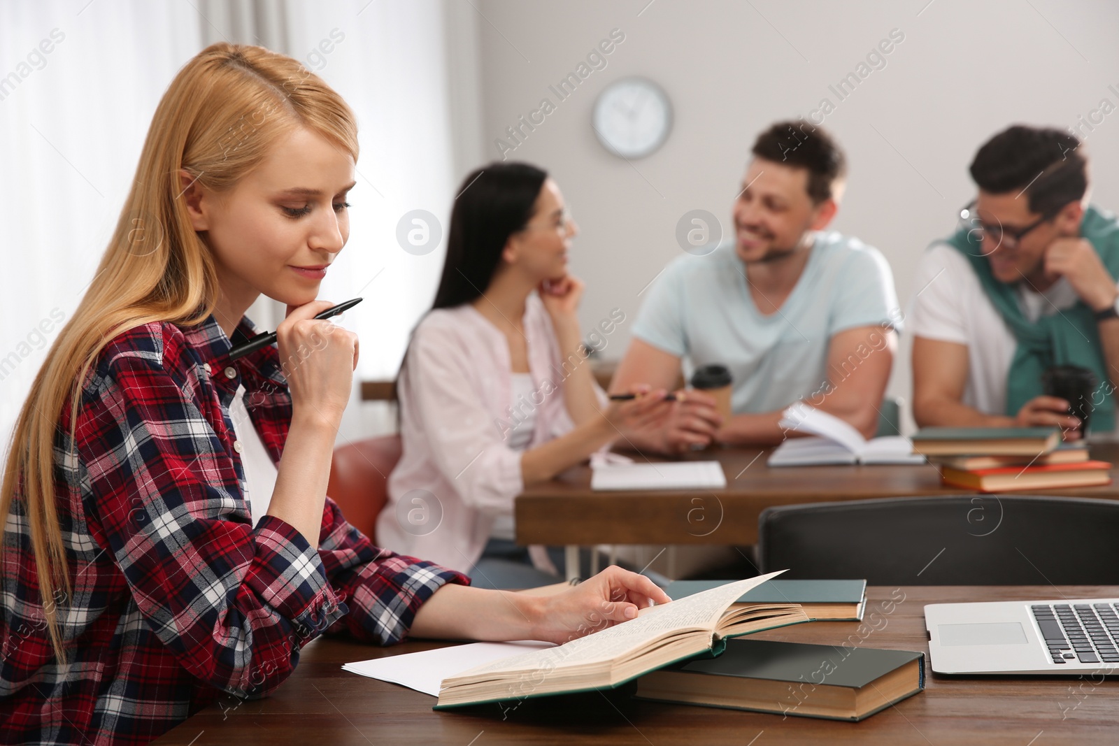 Photo of Students reading books and studying in library