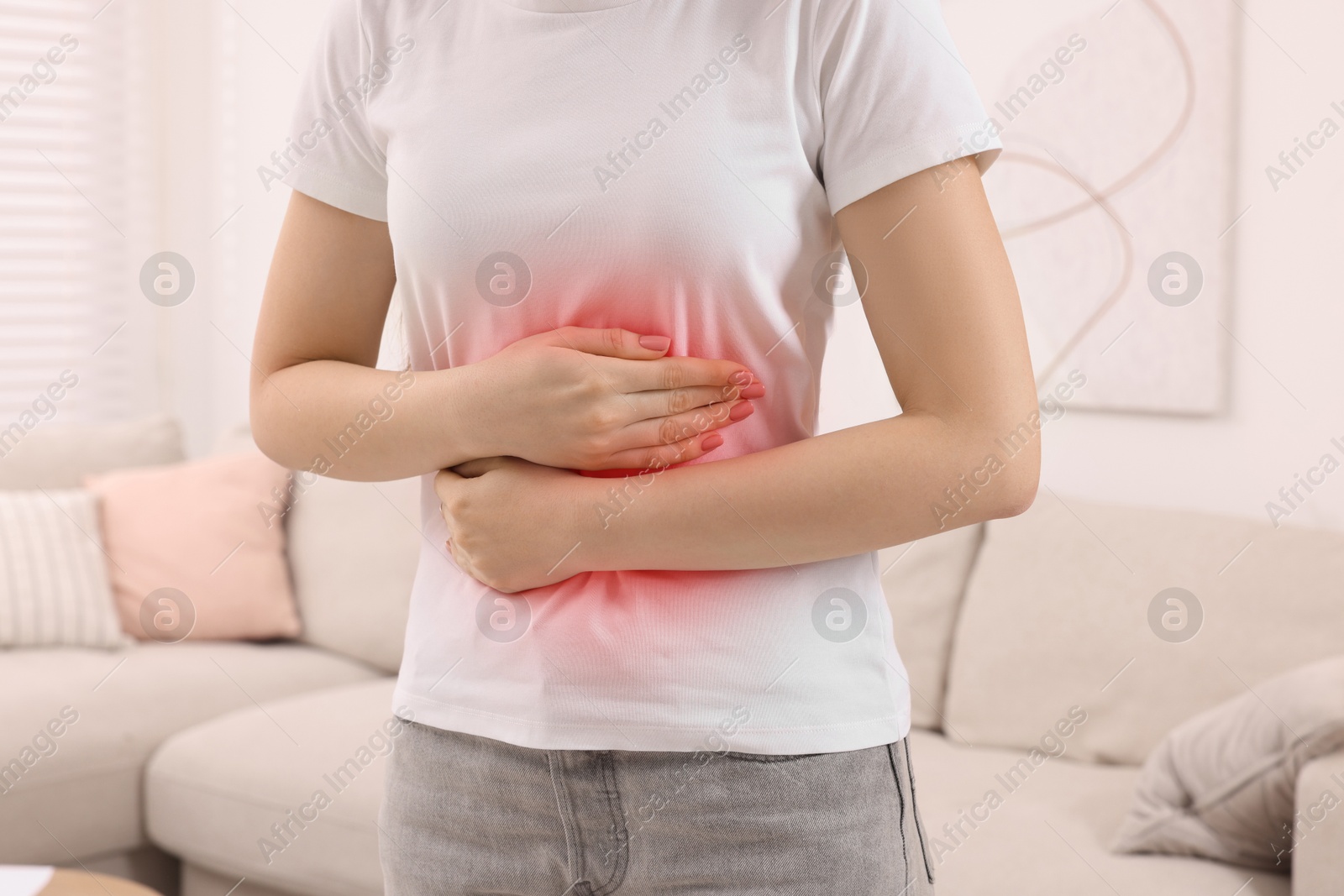 Image of Woman suffering from abdominal pain at home, closeup