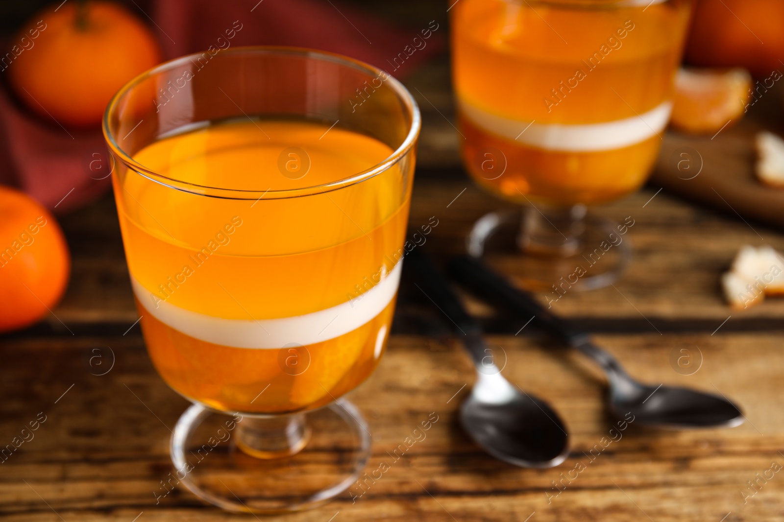 Photo of Delicious tangerine jelly on wooden table, closeup