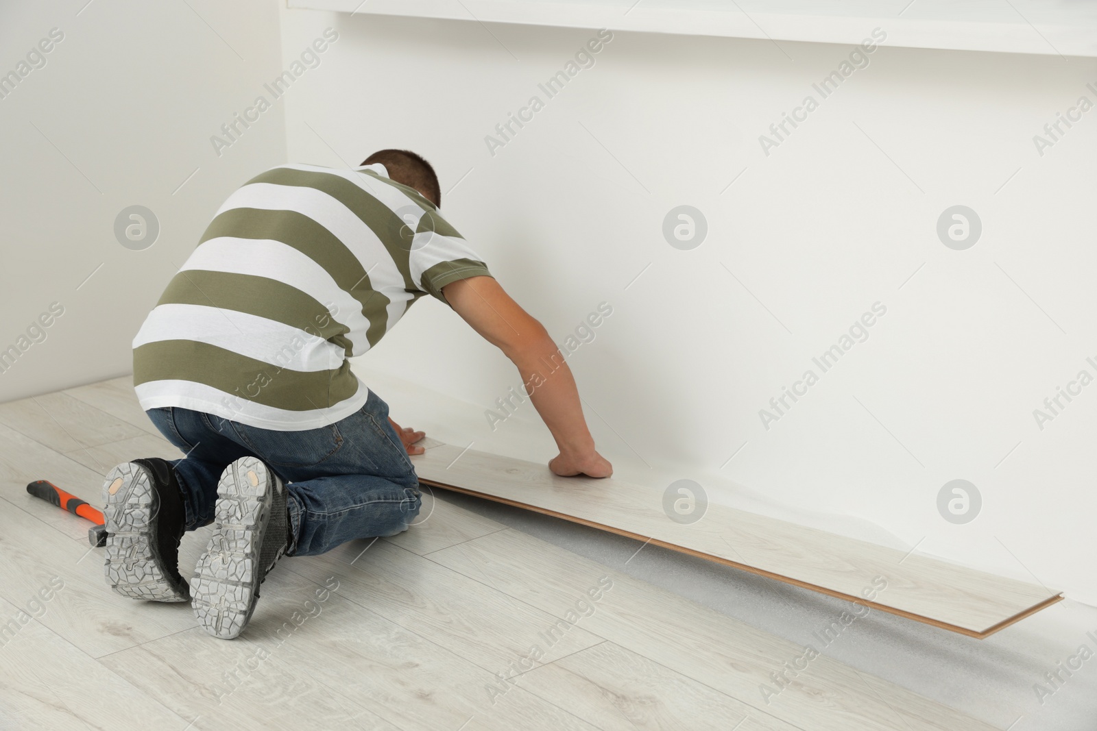 Photo of Professional worker installing new laminate flooring indoors