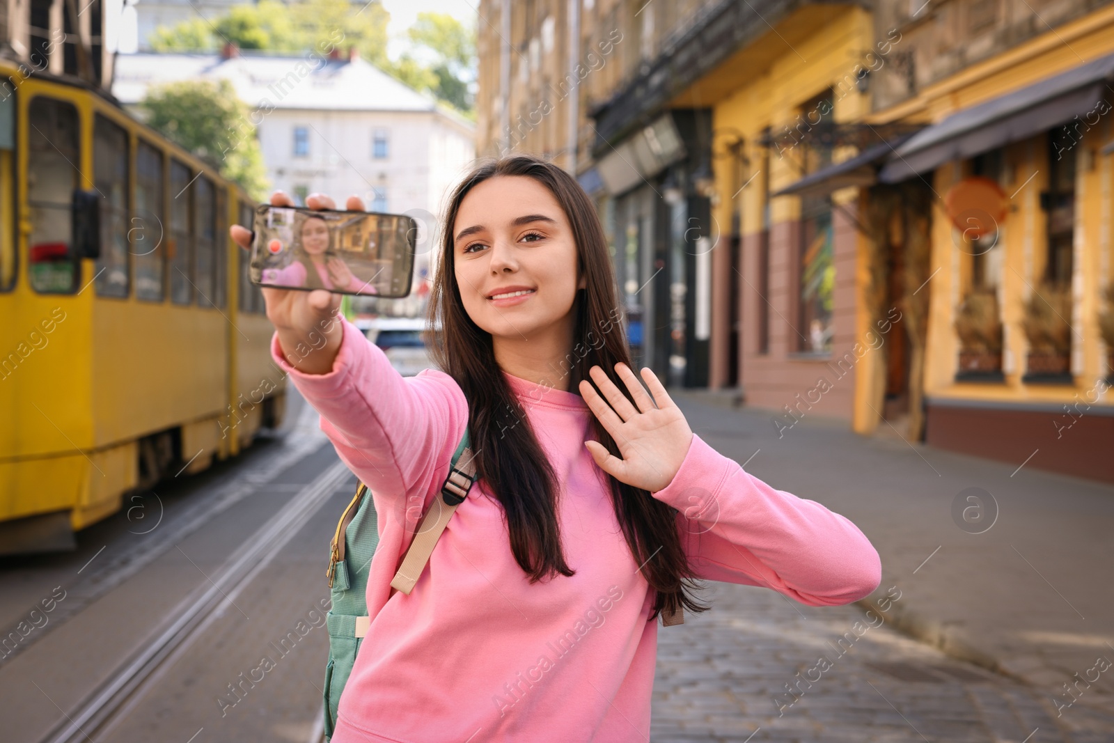 Photo of Travel blogger with smartphone streaming on city street