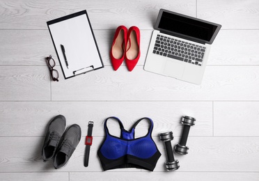 Flat lay composition with business supplies and sport equipment on white wooden floor. Concept of balance between work and life