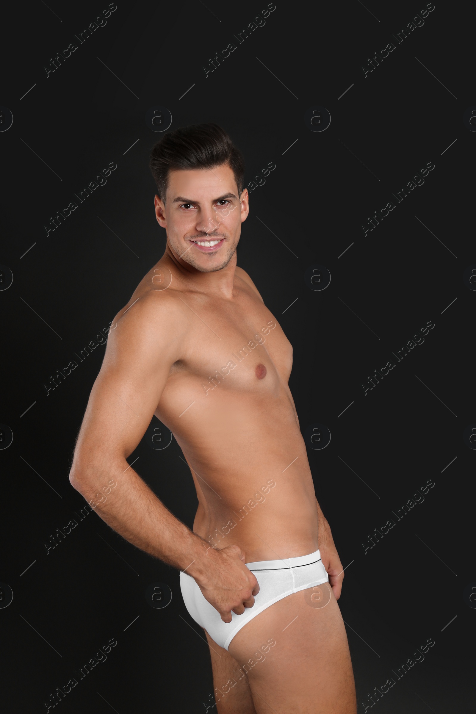 Photo of Handsome man in underwear on black background