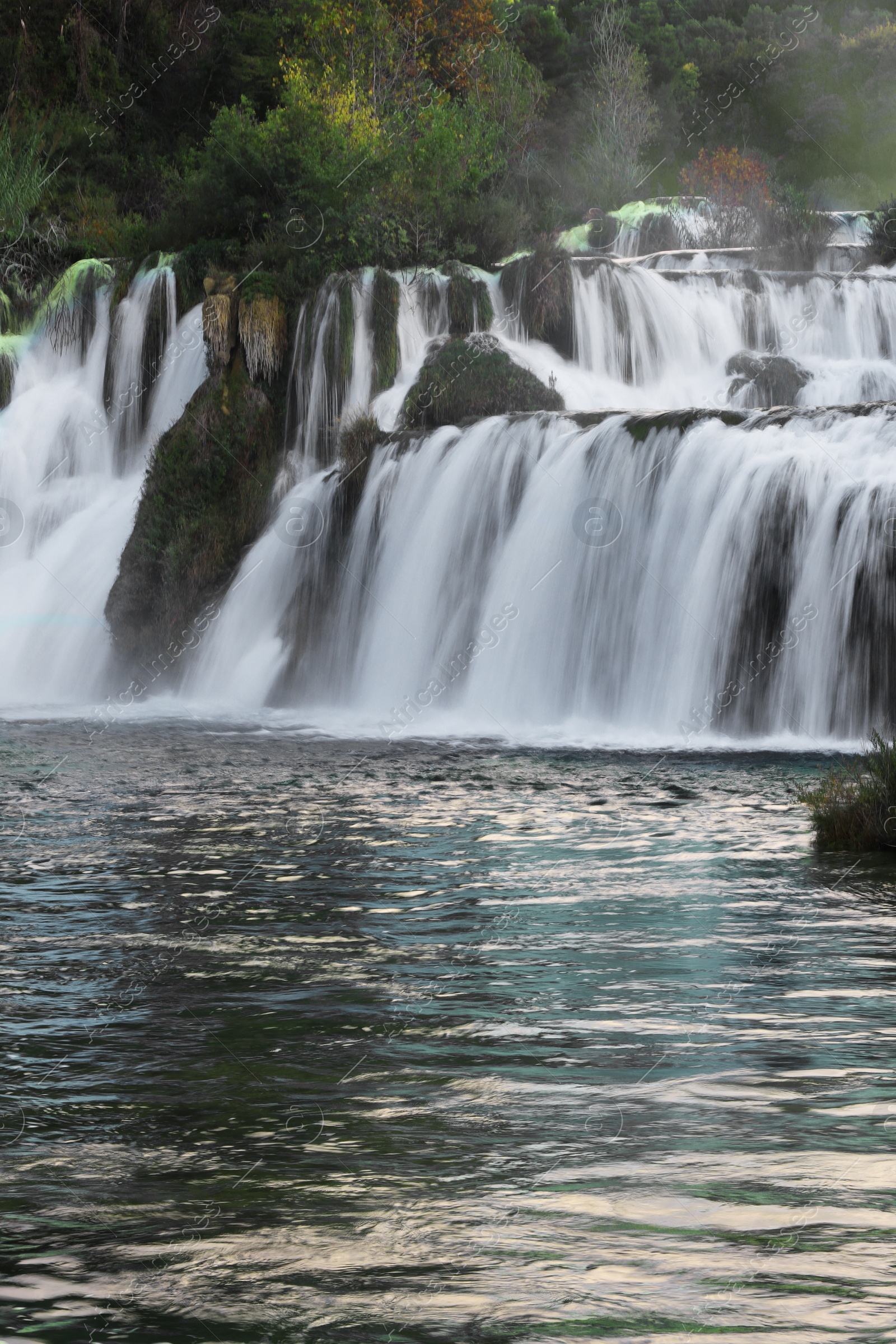 Photo of Picturesque view of beautiful waterfall and rocks outdoors