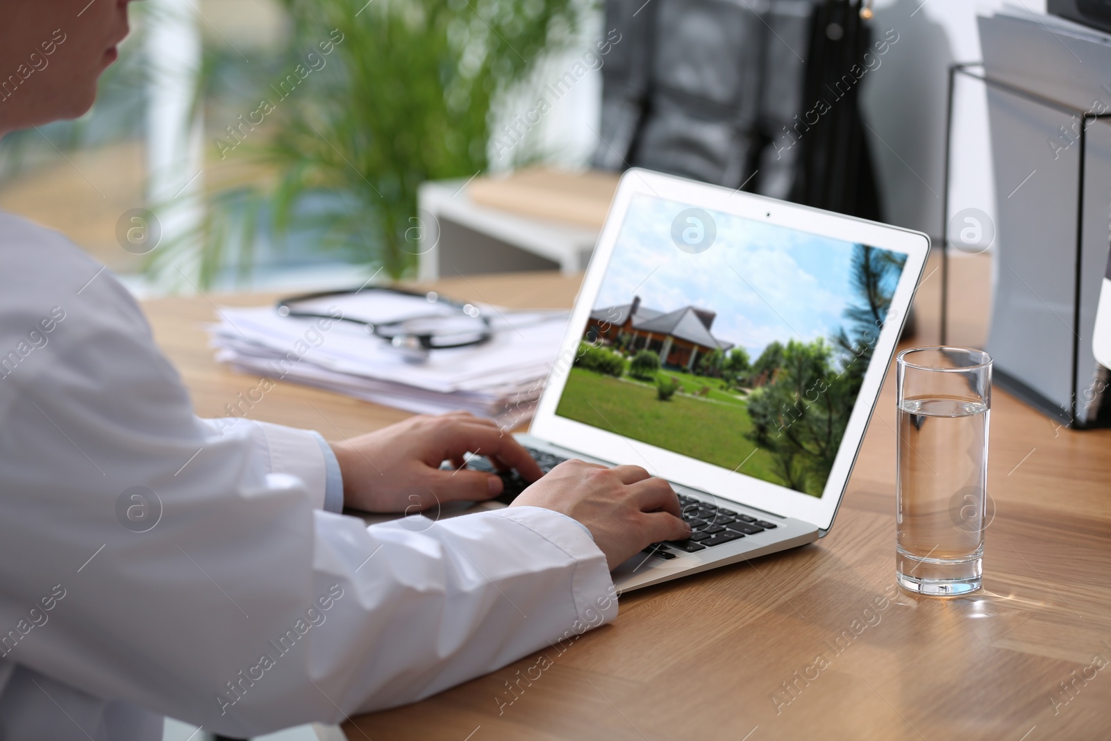 Image of Real estate agency online service. Doctor choosing new house via laptop, closeup