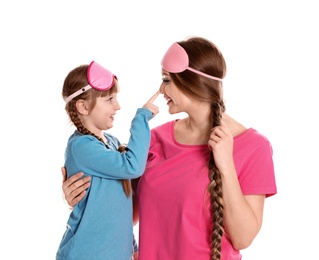 Happy woman and daughter in pajamas on white background