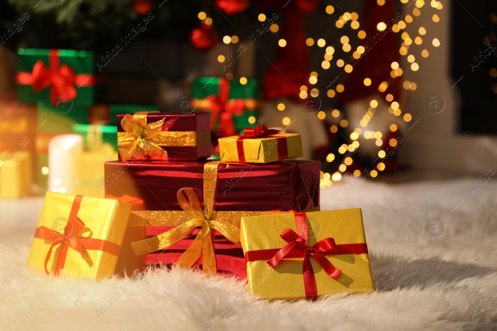 Photo of Beautiful Christmas gifts on furry carpet in room