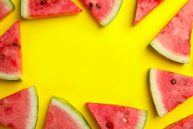 Photo of Frame made with slices of ripe watermelon on yellow background, flat lay. Space for text