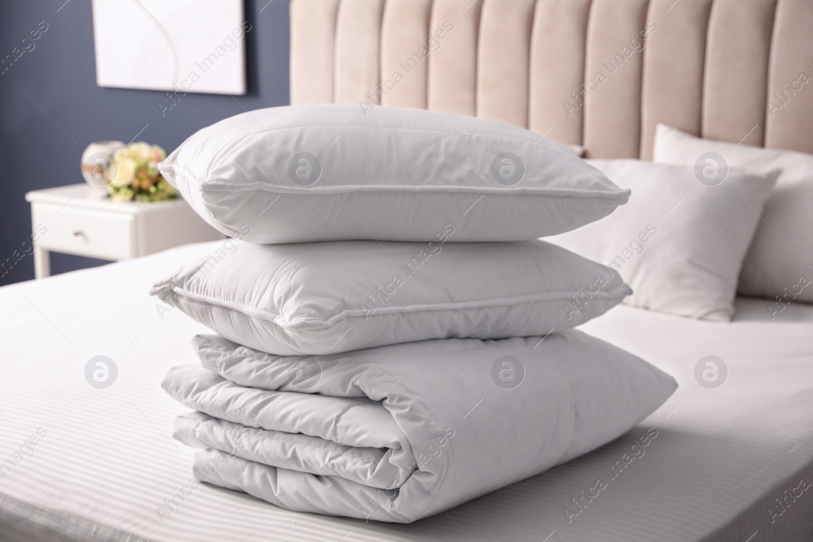 Photo of Soft folded blanket and pillows on bed indoors