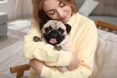 Woman with cute pug dog at home. Animal adoption