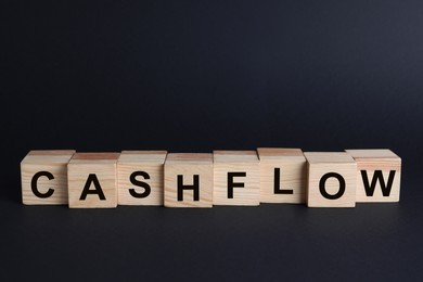 Image of Wooden cubes with phrase Cash FLow on black background