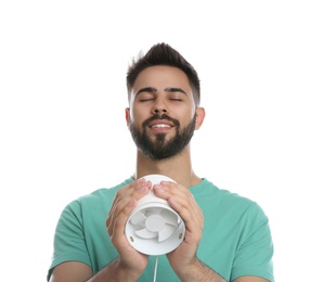 Photo of Man enjoying air flow from portable fan on white background. Summer heat