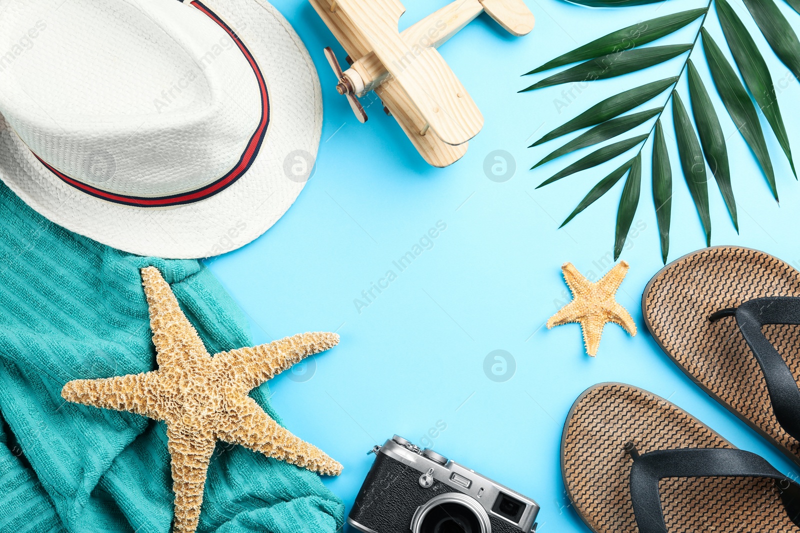 Photo of Flat lay composition with beach objects on light blue background. Space for text