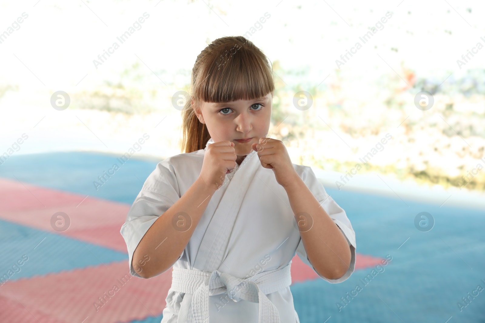 Photo of Girl in kimono practicing karate on tatami outdoors